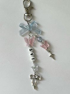 a key chain with some charms attached to it's side on a white surface