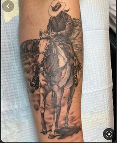 a man with a cowboy hat on his head riding a horse in the desert tattoo