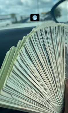 a bunch of money sitting on top of a car dashboard