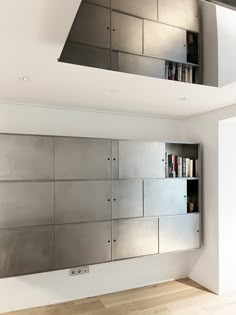 an empty room with stainless steel cabinets and bookshelves on the wall in front of it