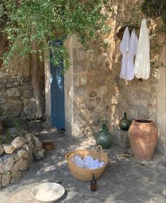 an outdoor area with stone walls and potted plants