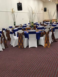 tables and chairs are set up in a banquet hall with blue sashes on them