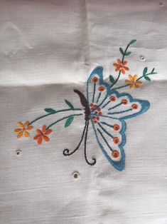 embroidered butterfly on white linen with orange and yellow flowers