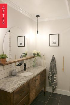 a bathroom with two sinks and a large mirror above the sink is next to a towel rack