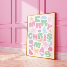 a pink room with a framed merry christmas poster on the wall and wooden flooring