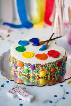 a birthday cake decorated with colorful icing and sprinkles on a table