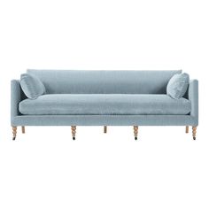 a gray couch with two pillows on it's legs and one arm resting against the back