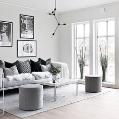 a living room filled with lots of furniture and pictures on the wall above it's windows