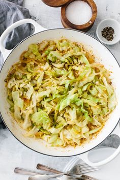 an image of cabbage in a pot with spoons on the side