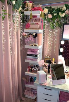 a room with pink curtains and shelves filled with cosmetics