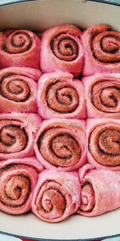 a pan filled with cinnamon rolls covered in powdered sugar