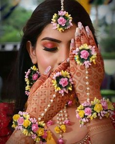 a woman with her hands on her face and flowers in the middle of her hand