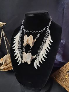 Have a Look at This Beautiful Gothic Coyote Vertebrae Bone Necklace!  There are 20 Real Raccoon Teeth Hanging Underneath. The ENTIRE Necklace is Stainless Steel. It is Adjustable up to 22 Inches. All Items Ship Within 1-3 Days via USPS Ground Advantage Service. Shipping on this will be 5.50 (USA Only) All additional items are FREE! International Shipping Will Be 22.00 + 2.00 For each Additional Item. Canada 20.00 + 2.00 For each Additional Item. International Shipping May Take 2 - 6 Weeks to Deliver I DO NOT Carry Human Bones or Any Sort of Illegal Items. And As Etsy Sellers, We Are Not Allowed to Sell Domesticated Dog or Cat Bones of Any Sort. All The Bones Here are Legal to Buy, Sell, And Own in the United States. Bone Crafts Necklaces, Raccoon Teeth, Cat Bones, Doctor Halloween, Witch Necklace, Human Bones, Witch Doctor, Necklace Gothic, Bone Necklace