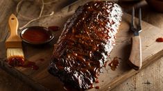 barbecue ribs covered in bbq sauce on a cutting board