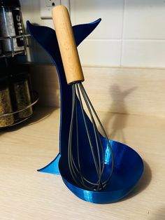 a whisk is sitting on top of a blue stand