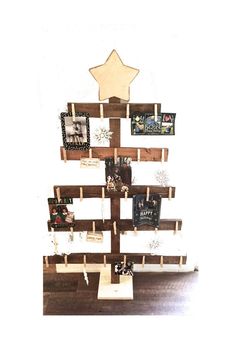 a christmas tree made out of wooden pallets with pictures hanging on the top and bottom