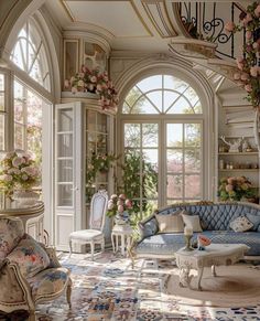 an ornate living room with blue couches and floral decorations on the windowsills