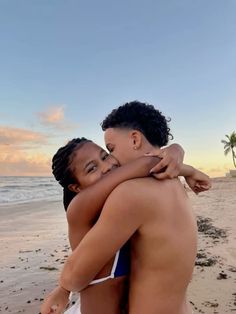 two women hugging each other on the beach