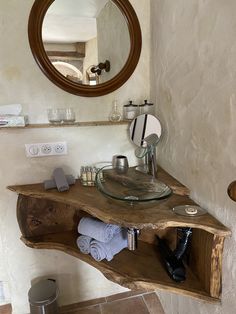 a bathroom with a sink, mirror and shelves on the wall next to each other