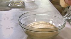 a person mixing ingredients in a glass bowl