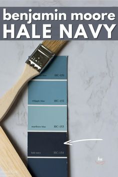 a paint brush sitting on top of a blue and gray color swatch with the words benjamin moore hale navy above it