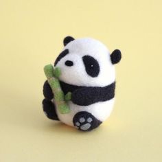 a small stuffed panda bear holding a bamboo stick