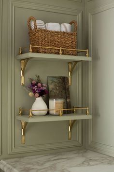 the shelves in the bathroom are decorated with gold and white dishes, vases and towels