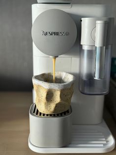 an espresso machine is pouring coffee into a cup