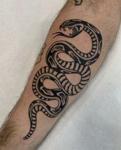 a man's arm with a black snake tattoo on it