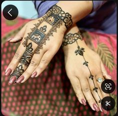 a woman's hands with henna tattoos on her left hand and the other hand is