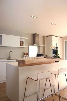 a kitchen with two bar stools next to an island