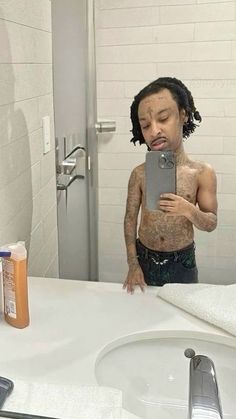 a man taking a selfie in front of a bathroom mirror