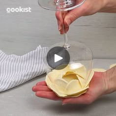 someone is holding a wine glass in their hand and pouring it into a bowl with the lid