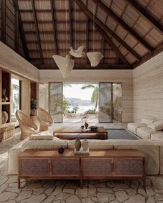 a living room filled with furniture and a large window covered in wood shinnings