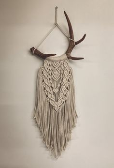 a deer's antler hanging on the wall with some tassels attached to it