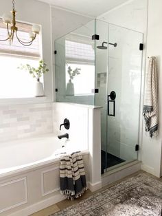 a bathroom with a bathtub, shower and rug