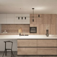 a modern kitchen with an island and bar stools next to the countertop area