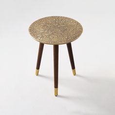 a small table with wooden legs and a flower design on it