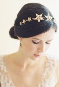 a woman in a wedding dress wearing a gold star tiara with pearls on her head