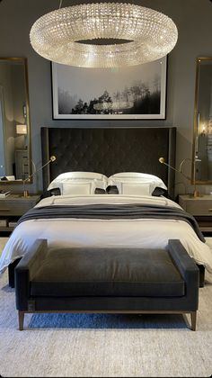 a large bed sitting under a chandelier in a bedroom