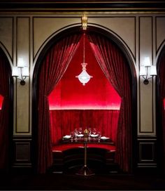 a room with red curtains and tables in it