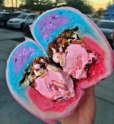 two ice cream sandwiches with sprinkles and toppings are held in the palm of someone's hand