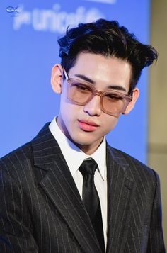 a man in a suit and tie wearing glasses