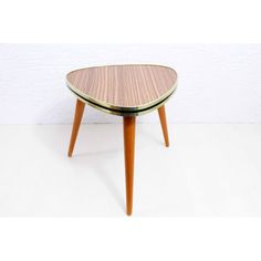 a small wooden table sitting on top of a white floor