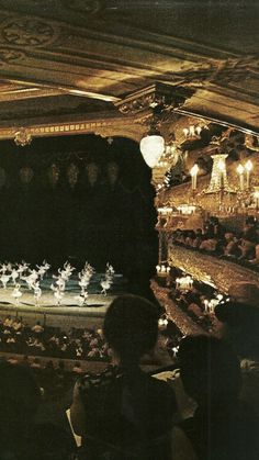 an auditorium filled with lots of people and lights