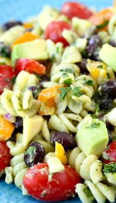 a colorful pasta salad is shown on a blue plate