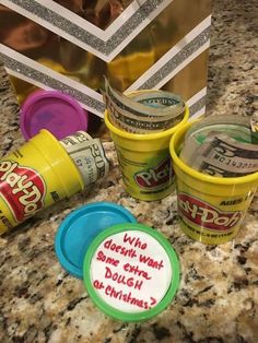 three cups with writing on them sitting on a counter next to a bag and some other items