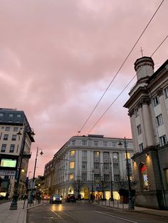 an empty city street at dusk with buildings on both sides