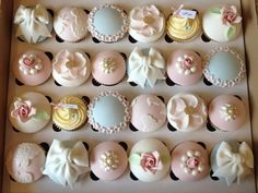 a box filled with lots of cupcakes covered in pink and white frosting