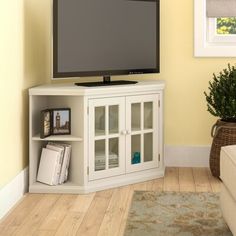 a flat screen tv sitting on top of a white cabinet